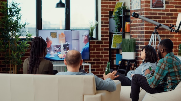 Wieloetniczna grupa przyjaciół oglądająca dramat w telewizji, ciesząca się filmem w programie kanału. Oglądanie programu telewizyjnego i picie piwa z butelek, zabawa podczas weekendowego spotkania.