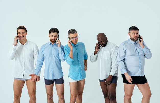 Wieloetniczni mężczyźni pozują do zestawu upiększającego w męskiej edycji. faceci w różnym wieku i ciele w bieliźnie bokserskiej i koszuli