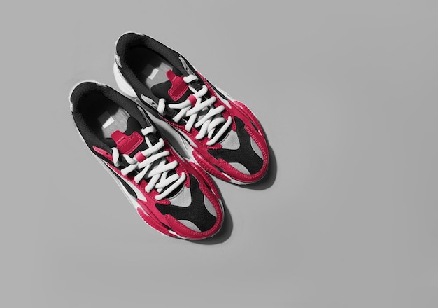 Wielokolorowe buty sportowe na tle. Nowy modny kolor PANTONE 18-1750 Viva Magenta w 2023 roku