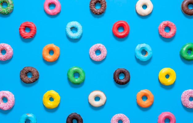Wielokolorowe donuts widok z góry wyizolowanych na niebieskim tle Oszklone donuts wzór