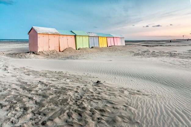 Wielokolorowe kabiny kąpielowe ustawione w kolejce na bezludnej plaży BerckPlage wczesnym rankiem