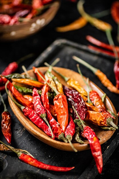 Wielokolorowe strąki suszonych papryczek chili na desce do krojenia