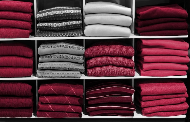 Wielokolorowy sweter zimowy na półkach sklepowych. Nowy modny kolor PANTONE 18-1750 Viva Magenta w 2023 roku