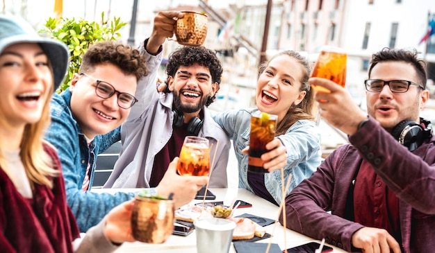 Wielokulturowi przyjaciele biorący selfie w fantazyjnej restauracji pubowej na zewnątrz - koncepcja stylu życia z młodymi ludźmi bawiącymi się razem w happy hour w kawiarni na chodniku - Żywy filtr z naciskiem na centralnego faceta