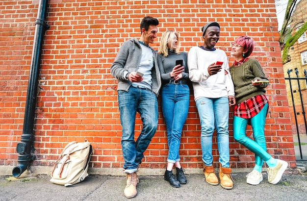 Wielokulturowi przyjaciele-hipster udostępniający treści na smartfonie w obszarze miejskim w Shoreditch w Londynie