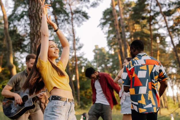 Wielonarodowa grupa ludzi piękna hipsterka tańcząca na tle przyjaciół bawiących się