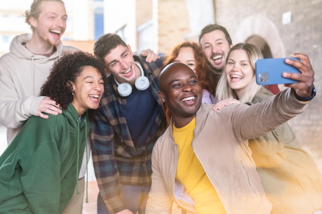 Wielorasowa grupa młodych ludzi biorąca selfie za pomocą smartfona Koncepcja szczęśliwego stylu życia