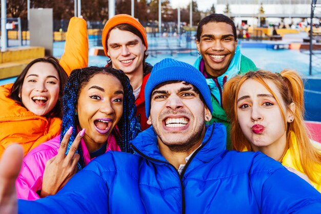 Zdjęcie wielorasowa grupa młodych przyjaciół spotykających się zimą na świeżym powietrzu
