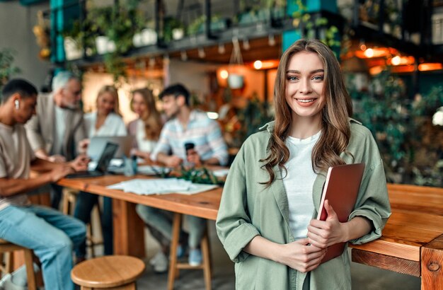 Wielorasowi kreatywni ludzie w nowoczesnym biurze. Grupa młodych ludzi biznesu i starszy szef pracują razem z laptopem, tabletem, smartfonem, notebookiem, wykresami. Zgrany zespół w coworkingu