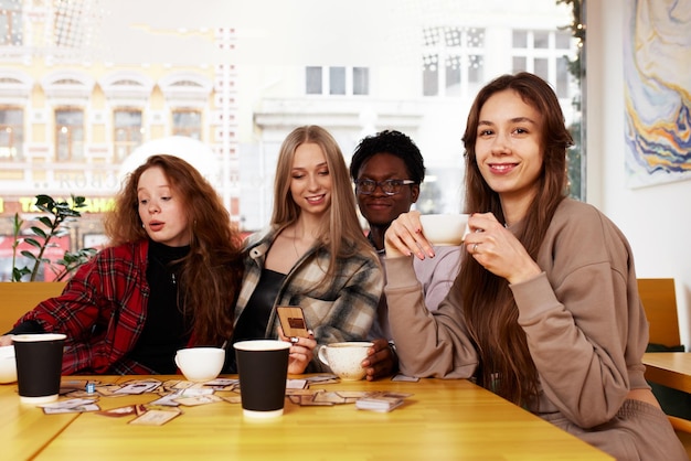Wielorasowi Przyjaciele Dziewczyny I Chłopaki Bawią Się śmiejąc Się Pijąc Kawę Herbatę W Kawiarni Szczęśliwi Różnorodni Młodzi Ludzie Rozmawiają żartując Siedząc Razem Przy Stoliku W Kawiarni Wielokulturowa Koncepcja Przyjaźni