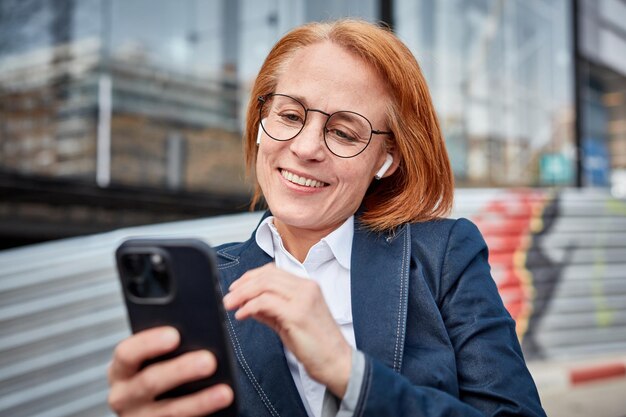 Wielozadaniowa bizneswoman w średnim wieku, znajdująca swój rytm w miejskim świecie biznesu