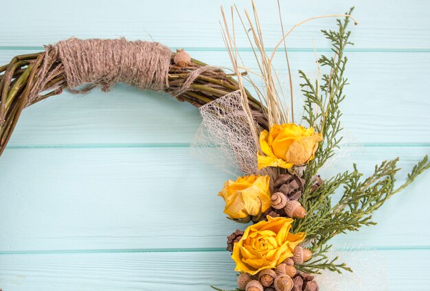 Wieniec z winorosli z rózami. Handmade decor.Wreath rzeczywistych gałązek na drewnianym tle