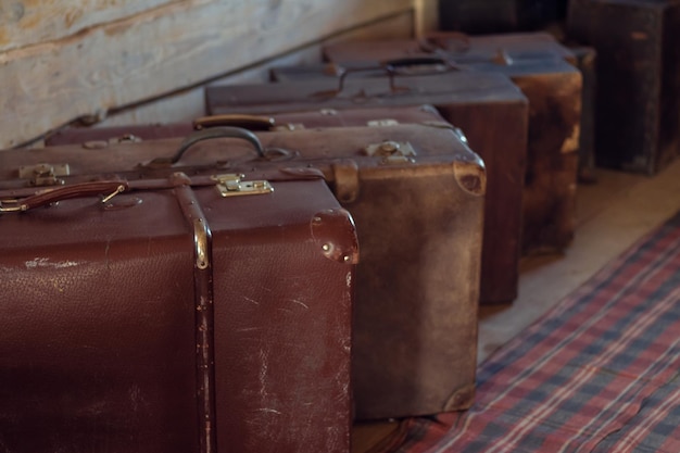 Wiersz antyczne shabby walizki na podłodze w drewnianym wiejskim domu Brown leather old fashioned bagage for travelling