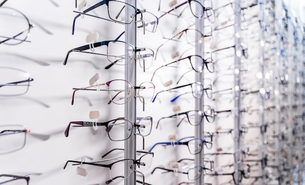 Wiersz okularów u optyka. Sklep z okularami. Stań z okularami w sklepie z optyką. Prezentacja z okularami w nowoczesnym sklepie okulistycznym. Zbliżenie.