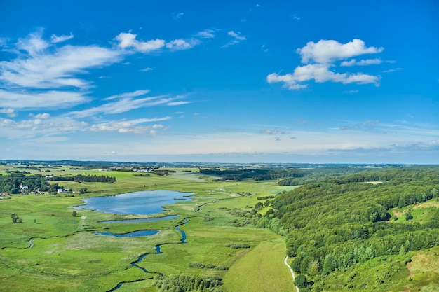 Wieś Jutlandii Dania Piękny krajobraz przedstawiający duńskie bezdroża Pastwiska w jasny letni dzień z bujną zielenią rozkwitającą i błękitnym niebem wypełnionym chmurami