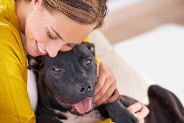 Więź między psem a właścicielem Przycięte zdjęcie atrakcyjnej młodej kobiety przytulającej się z psem na kanapie
