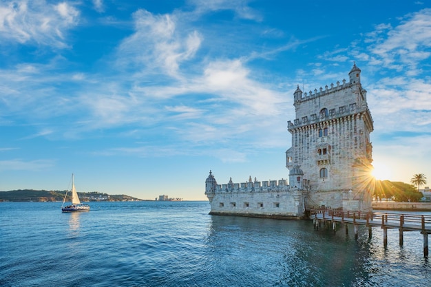 Wieża belem na brzegu rzeki tag na zachodzie słońca lizbona portugalia