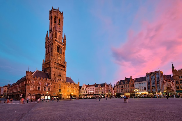 Wieża dzwonnica i plac Grote Markt w Brugii w Belgii o zmierzchu