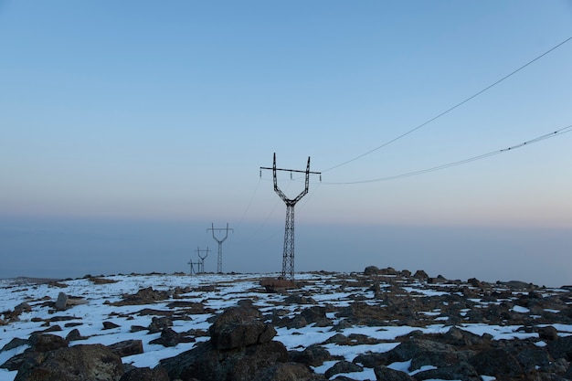 Wieża elektryczna w zimie o zachodzie słońca