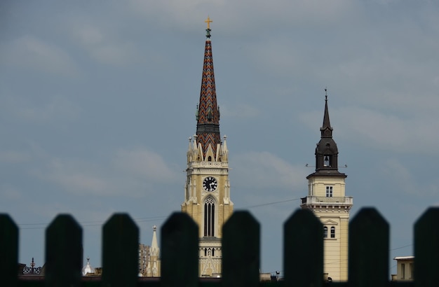 Wieża ratuszowa i wieża kościelna przez ogrodzenie