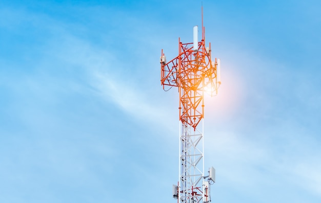 Wieża telekomunikacyjna z błękitne niebo i białe chmury w tle. Antena na niebieskim niebie. Słup radiowy i satelitarny. Technologia komunikacyjna. Przemysł telekomunikacyjny. Sieć komórkowa lub telekomunikacyjna 4g.