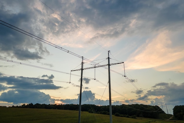 Wieża wysokiego napięcia z liniami energetycznymi o zachodzie słońca