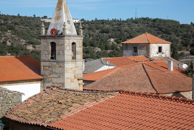 Wieża zegarowa kościoła i dachy wyłożone kafelkami w wiosce Castelo Mendo