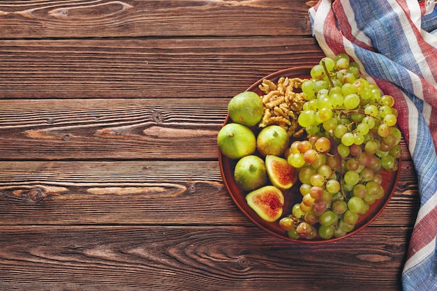 Winogrono, ser, figi i miód z winem na drewnianym stole