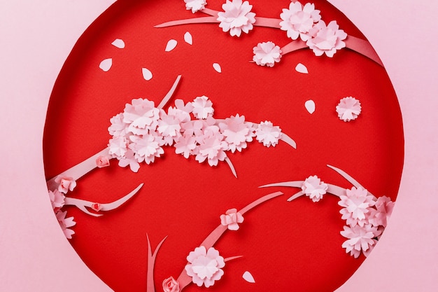 Zdjęcie wiosenna kompozycja papercraft z gałęzią sakury na różowym i czerwonym