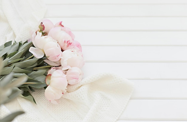 Wiosenna kompozycja z różowymi tulipanami na drewnianym tle Płaska świecąca ramka w kwiaty i biała tkanina Widok z góry na obramowanie