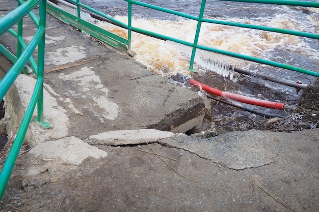 Wiosenna powódź Woda pływająca w rzece Ciemna woda żelazna pływa w strumieniu Karelia Rzeka Lososinka wiosną Powodzie tsunami i zmiana klimatu Zniszczony most z rurami Katastrofa pogodowa