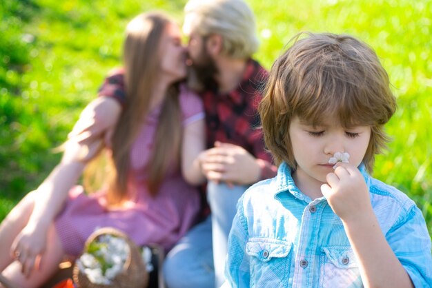 Wiosenna rodzina na pikniku w plenerze Lato rodzic z dzieckiem w ogrodzie lub parku Rodzicielstwo razem koncepcja wypoczynku Pocałunek żony i męża