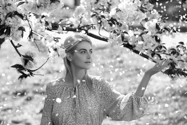 Wiosenne dziewczyny w kwiatach piękna kobieta w ogrodzie kwitnącym wiśni na wiosenne płatki kwiatów falli