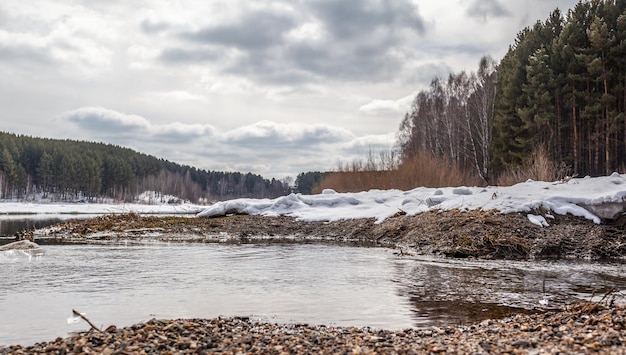 Wiosenne strumienie w przyrodzie. Śnieg topnieje i płyną czyste strumienie. Natura na tle jezior i lasów