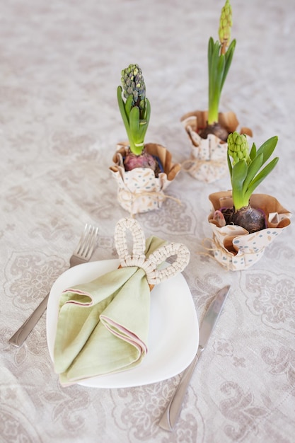 Wiosenne świąteczne nakrycie stołu z serwetkami w kwiaty i uroczym wystrojem króliczka na lnianym obrusie Czas wielkanocny Przytulny dom