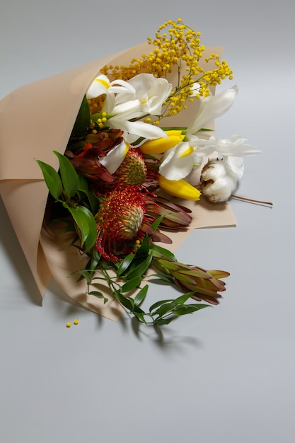 Wiosenny bukiet ruscus, leucadendron, leucospermum, irys, bawełna, gałąź mimozy, tulipan, selektywne focus