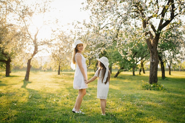 Wiosenny spacer po kwitnącym jabłoniowym ogrodzie uroczej matki i jej córki
