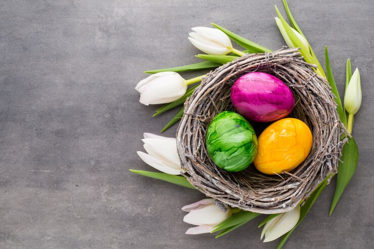 Wiosna z życzeniami. Pisanki w gnieździe. Wiosenne kwiaty tulipany.
