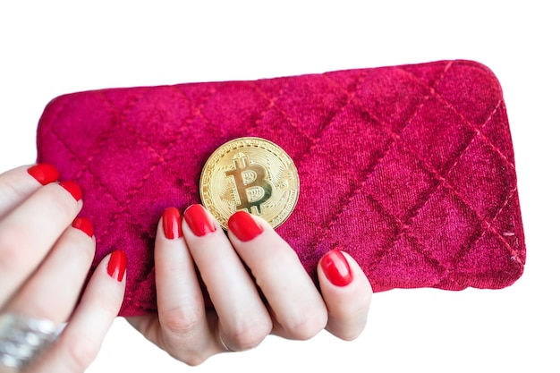 Wirtualne pieniądze złoty bitcoin na różowych palcach torebki damskiej z czerwonymi paznokciami na monecie na białym tle