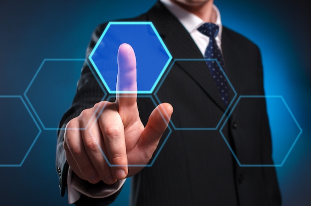 Zdjęcie wirtualny wyświetlacz multimedialny. mężczyzna w garniturze i krawacie klika palcem wskazującym na wirtualnym ekranie.