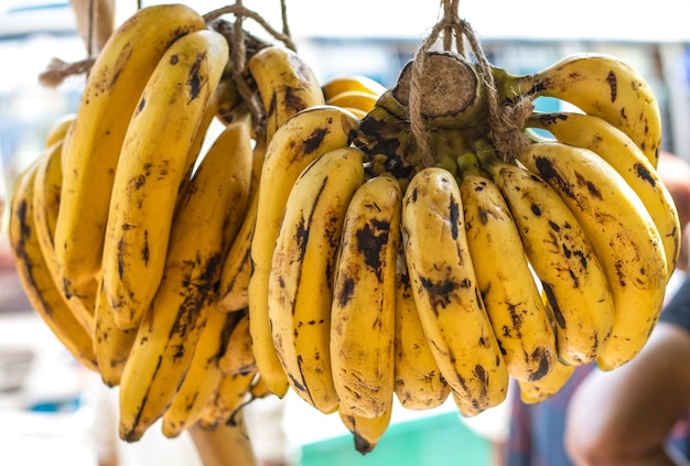 Wiszące dojrzałe kiście bananów na stoisku z herbatą przy drodze z bliska