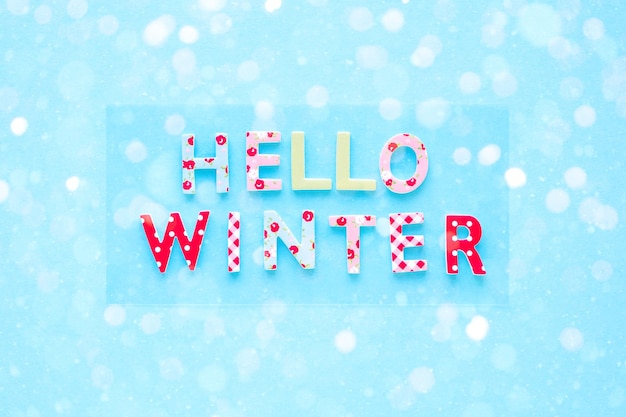 Witaj zima tło z kolorowymi literami i śniegiem Płaski świecki widok z góry