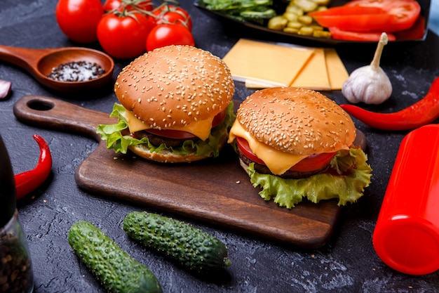 Wizerunek dwa hamburgera na drewnianej desce, ser
