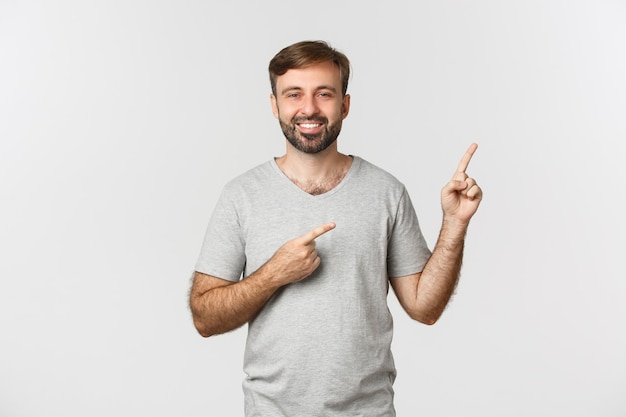 Wizerunek szczęśliwy przystojny facet z brodą, na sobie szarą koszulkę