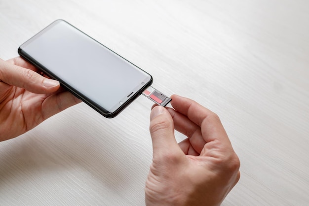 Wkładanie adaptera SIM i mini SD do koncepcji telefonu Trzymając za rękę adapter i wkłada go do telefonu