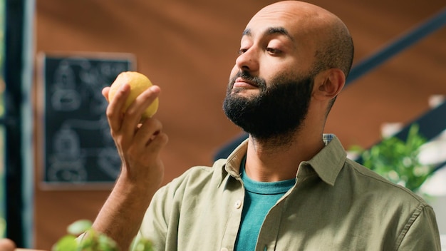 Właściciel sklepu daje klientom cytryny do wąchania i cieszenia się aromatycznym świeżym zapachem cytrusów. Mężczyzna kupuje produkty lokalnie uprawiane w celu wsparcia lokalnego zrównoważonego biznesu i sklepikarza.