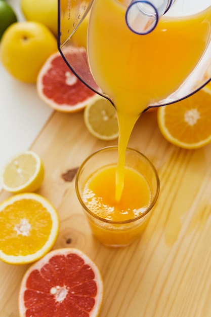 Wlewanie świeżego soku pomarańczowego do szklanki