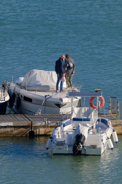 Włochy Sycylia Morze Śródziemne Marina di Ragusa Prowincja Ragusa ludzie na luksusowym jachcie w porcie