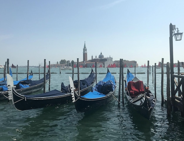 Włochy, Wenecja. Na zdjęciu promenada, łódki, latarnia. W tle miasto.