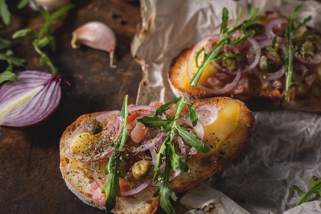 Włoska bruschetta z posiekaną cebulą, rybą, kaparami i octem balsamicznym